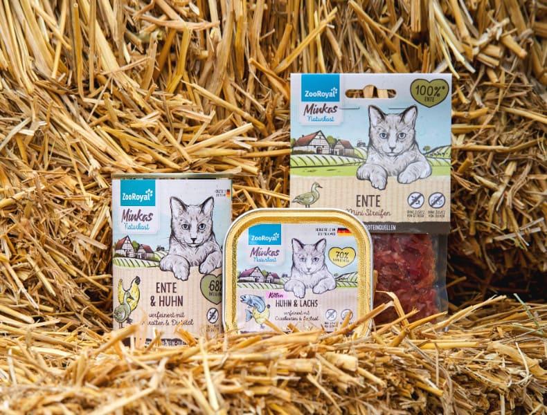 Minkas Naturkost Produkte im Stroh Minkas Naturkost Katzenfutterprodukte stehen im Stroh.