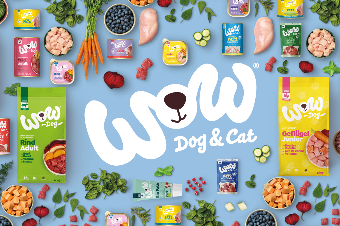 WOW Dog & Cat Aktionsbanner für Hunde‑ und Katzenfutter von WOW. Verschiedene Produkte wie Trocken‑ und Nassfutter sowie Zutaten wie Gemüse und Fleisch sind rund um ein großes WOW‑Logo angeordnet, Hinweis auf natürliches Sortiment für Hunde und Katzen.