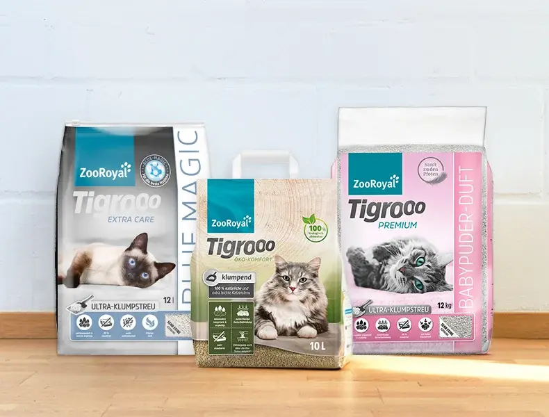Tigrooo Katzenstreu Sortiment Drei Sorten ZooRoyal Tigrooo Katzenstreu stehen nebeneinander auf einem Holzboden.